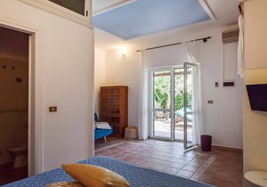 Inviting cottage with charming outdoor area and limited sea view.