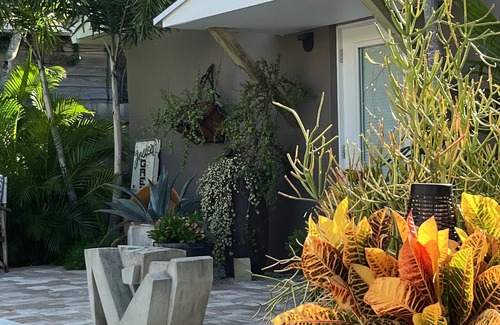 Parrot Cove Cottage | Chill on the patio overlooking the pool & lush gardens with privacy!
