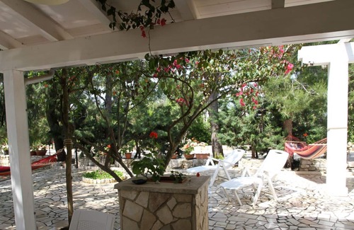 Brindisi House | cottage surrounded by trees and flowers