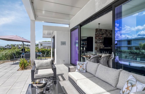 Zeewolde House | Detached 6-person villa by the water with a cosy living room featuring a piano and fireplace, modern kitchen with cooking island, and a sunny garden with lounge set.