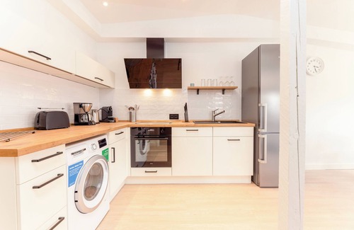 Wenningstedt-Braderup Apartment | Fließende Übergänge, Freigelegtes Mauerwerk, ein Mix aus Weiß und Grau Gepaart m