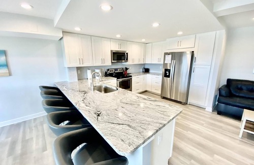 Rehoboth Beach Condo | LINENS & DAILY ACTIVITIES INCLUDED! OCEANFRONT/BOARDWALK BUILDING W/ROOFTOP POOL Completely remodeled kitchen with all-new cabinets and appliances, open floor plan and eat-at counter.