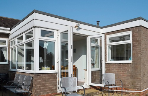 Beadnell Cottage | Modern accommodation with sun room and patio overlooking a small lake.