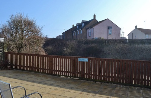 Beadnell Cottage | Modern accommodation with sun room and patio overlooking a small lake.