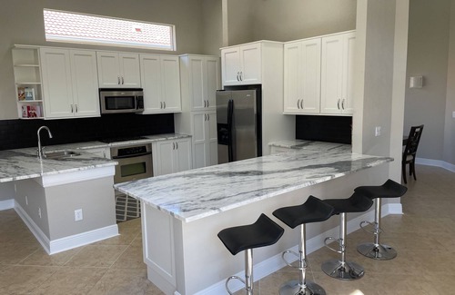 Estero House | Renovated open floor plan with large heated pool and screened lanai with dining.