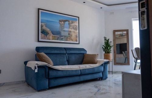 Bugibba Apartment | Seafront Bugibba apartment with balcony and stunning 180° views. Bright, beach-style interiors, lift access, and steps from dining and the shoreline.