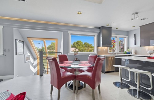 Hough Apartment | Top-level duplex featuring a sleek open concept kitchen with stainless appliances, cozy fireplace, stylish furnishings, and in-unit washer/dryer. Designed for basking in the sun under skylights in thoughtful details throughout.