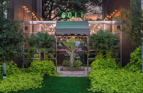 Lower Greenville Condo | Upscale 2BR Dallas condo with pool view and access to an award-winning courtyard featuring a resort-style pool, hot tub, dry sauna, and lush lounge areas. Enjoy a 77″ smart TV, sleek leather sofa, and modern kitchen for a stylish, comfortable stay.