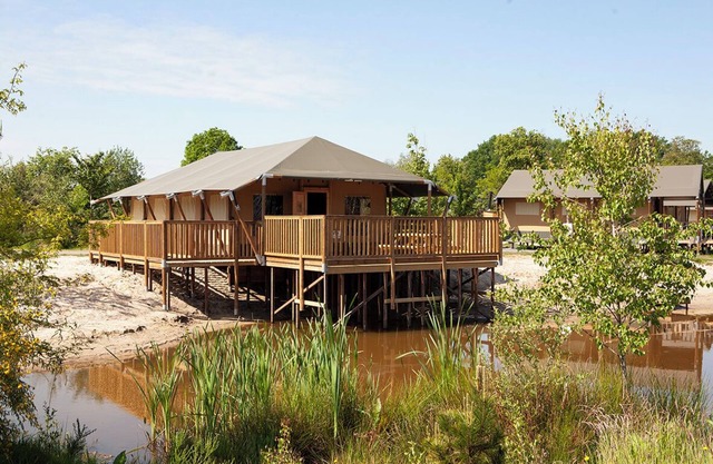 Enjoy the ultimate glamping experience in the Safaricottage XL for 8 people by the pond at Vakantiepark de Sallandshoeve, perfect for families and nature lovers.