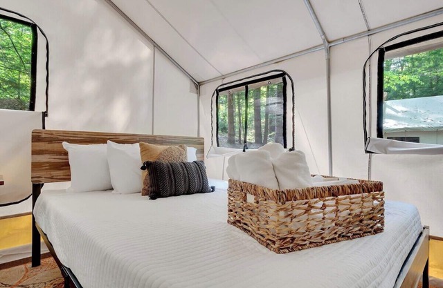 Unplug in comfort—glamping tent with real beds, electricity, fire ring, bathhouse, and nearby pond.
