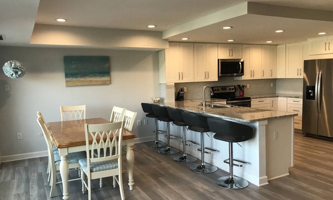 Rehoboth Beach Condo | LINENS & DAILY ACTIVITIES INCLUDED! OCEANFRONT/BOARDWALK BUILDING W/ROOFTOP POOL Completely remodeled kitchen with all-new cabinets and appliances, open floor plan and eat-at counter.