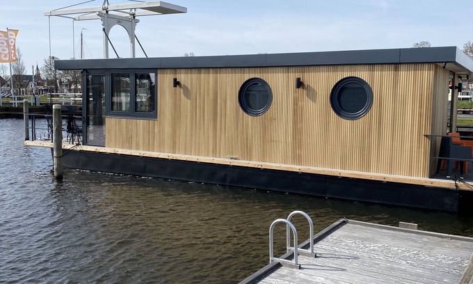 Stavoren Boat Rental | Luxury Houseboat with swim platform in colorful harbor