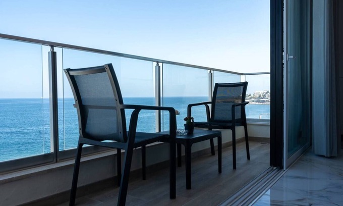 Bugibba Apartment | Seafront Bugibba apartment with balcony and stunning 180° views. Bright, beach-style interiors, lift access, and steps from dining and the shoreline.