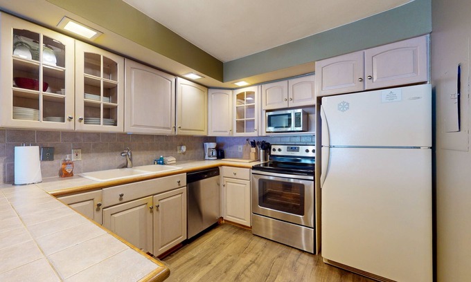 Mendon Condo | Secluded home with gas fireplace, patio, pool, athletic courts, & laundry room