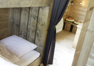 Tent lodge with covered terrace, in a holiday park in a green environment