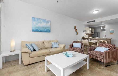 Boegoeroei Condo | Gated community with resort-style amenities - 2 bedroom, 2 bath with an open concept living room and kitchen. Private balcony overlooks pool area.
