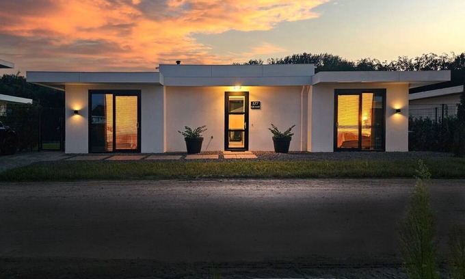 Zeewolde Cabin | Detached 6-person villa with paddleboards, waterfront garden with private swim deck, sunshade, BBQ, and luxurious open kitchen. Located at Villa Resort Harderwold in Zeewolde. Pet-friendly!